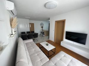 a living room with a white couch and a flat screen tv at New apartment near Split with garage in Solin