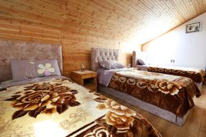 2 camas en una habitación con paredes de madera en Samuela Cozy Retreat en Berat
