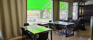 オ・ペドロウソにあるHostel Azul Cieloのテーブル2台と椅子、窓が備わる客室です。