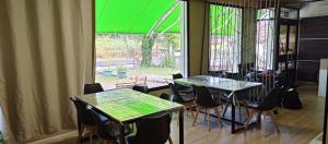 a room with two tables and chairs and a window at Hostel Azul Cielo in O Pedrouzo