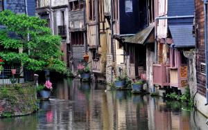un fiume in una città con edifici e acqua di Le Rislois des Baquets - Studio moderne et cosy a Pont-Audemer