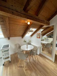 a dining room with wooden ceilings and a table and chairs at BullsLiving Seeapartment 6 Am Corso in Velden am Wörthersee +3 photos