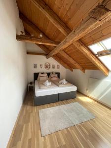 - une chambre avec un lit dans une pièce dotée de plafonds en bois dans l'établissement BullsLiving Seeapartment 6 Am Corso, à Velden am Wörther See