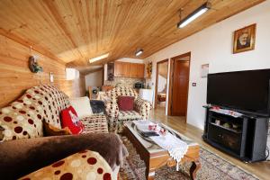 a living room with couches and a flat screen tv at Samuela Cozy Retreat in Berat