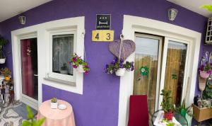 a purple building with a clock on the side of it at Mira in Pula