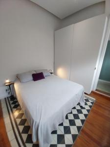 1 dormitorio con cama blanca y suelo a cuadros en SANTELMO en Buenos Aires