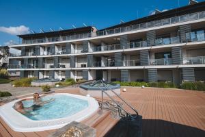 a large building with a hot tub in front of a building at Imola Hotel Platán in Eger