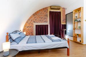 Ce lit se trouve dans une chambre dotée d'un mur en briques. dans l'établissement Studio77 maisonette, à Veliko Tarnovo