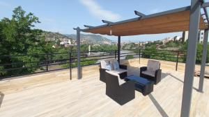 a deck with two chairs and a gazebo at Hotel Tradicia in Tbilisi City