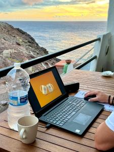 a person sitting at a table with a laptop computer at La Gloria del Norte in Las Palmas de Gran Canaria