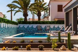 a villa with a swimming pool and palm trees at Villa in south of Tenerife in Arona