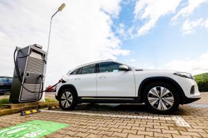 un coche blanco está estacionado junto a un semáforo en Business Hotel Conference Center & Spa, en Târgu Mureș