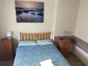 1 dormitorio con 1 cama y 2 mesitas de noche en Becontreelodge en Dagenham