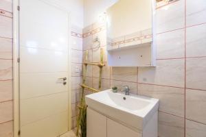 a white bathroom with a sink and a mirror at Nikos Seaside Apartment in Agia Pelagia Chlomou