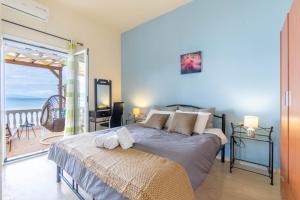 a bedroom with a bed and a balcony with the ocean at Nikos Seaside Apartment in Agia Pelagia Chlomou