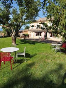 a group of tables and chairs in a yard at Le Petit Caboulot en pleine nature in Vaumeilh