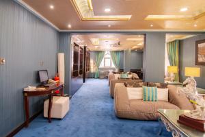 Garden Hotel Muscat By Royal Titan Group في مسقط: غرفة معيشة مع كنبتين وطاولة