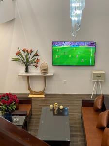 ein Wohnzimmer mit einem an der Wand hängenden TV in der Unterkunft Vedana resort in Chi Phương