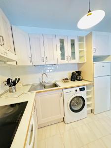 a kitchen with a washing machine and a sink at Sea view apartment in Los Cristianos in Arona