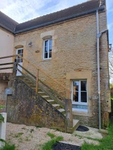 a brick building with a staircase in front of it at Petite vague - maison atypique avec terrasse in Saint-Aubin-sur-Mer