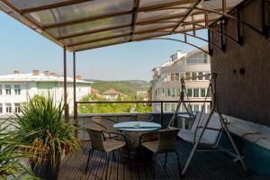 d'une terrasse avec une table et des chaises sur un balcon. dans l'établissement Studio77 maisonette, à Veliko Tarnovo