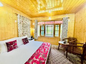 a bedroom with a bed and a wooden ceiling at Lidder Front Resort By Stay Pattern in Pahalgām