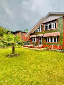 a house with a green lawn in front of it at Lidder Front Resort By Stay Pattern in Pahalgām