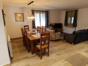 a dining room and living room with a table and chairs at Casa Rural Fort de Bernat in Cerler