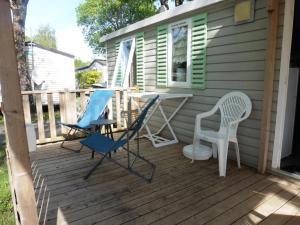 a deck with two chairs and a desk on it at Mobil home Saint Georges de Didonne in Saint-Georges-de-Didonne