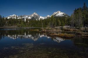 a large lake with snow capped mountains in the background at Štúdiá Správa TANAPu in Vysoke Tatry - Strbske Pleso