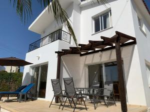 een patio met stoelen en een parasol en een gebouw bij Coral Bay Sunbeam Villa in Coral Bay