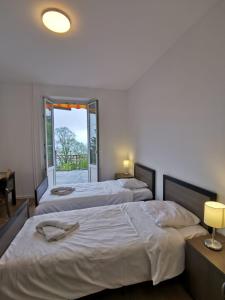 2 Betten in einem Zimmer mit 2 Lampen und einem Fenster in der Unterkunft Buffet de la gare 