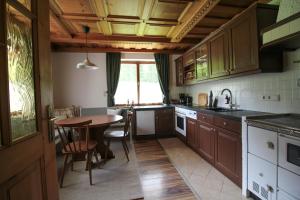 a kitchen with wooden cabinets and a wooden table at Frieda's Platzl in Abtenau