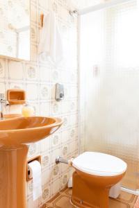 a bathroom with a sink and a toilet at Casa Aconchego - O refúgio perfeito para amar e descansar in Peruíbe +13 photos