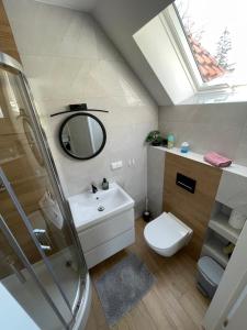 y baño con lavabo, espejo y aseo. en Apartament Rybical - POKOJE, en Ryn