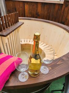eine Flasche Champagner und zwei Gläser auf dem Tisch in der Unterkunft Vila Clabucetul Baiului in Buşteni