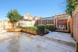 a patio with a fence and a table and chairs at Stunning family home, walking distance to Herne Bay Beach! in Kent