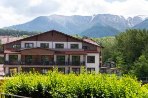 a large house with mountains in the background at Почивен комплекс Минкови бани in Varshets