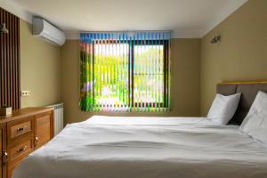 a bedroom with a large bed and a window at Почивен комплекс Минкови бани in Varshets +11 photos