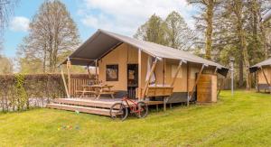 貝爾特里的住宿－Ardennen Camping Bertrix，帐篷,有一辆自行车停放在草地上