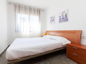 a bedroom with a bed with a wooden headboard and a window at Apartment Marina by Interhome in Lloret de Mar