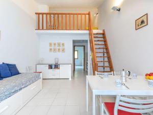a kitchen and living room with a table and a staircase at Apartment Cala Rossa-2 by Interhome in Nisporto