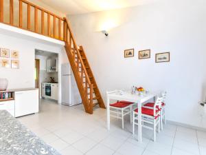 a kitchen and dining room with a white table and chairs at Apartment Cala Rossa-2 by Interhome in Nisporto