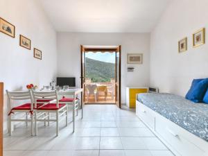 a bedroom with a bed and a table and chairs at Apartment Cala Rossa-2 by Interhome in Nisporto