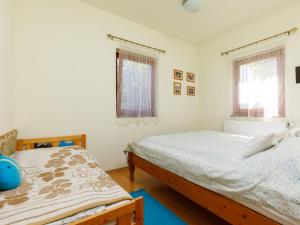 a bedroom with two beds and two windows at Holiday Home Juglans 1 by Interhome in Balatonakali