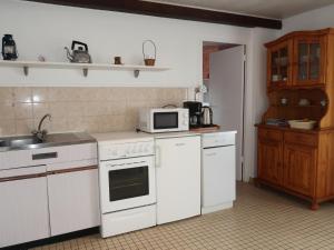 een keuken met witte apparatuur en een magnetron bij Holiday Home Ti an Naod by Interhome in Plouescat