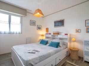 ein Schlafzimmer mit einem großen Bett mit blauen Kissen in der Unterkunft Apartment Plein Sud-1 by Interhome in Quiberon