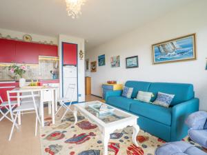 ein Wohnzimmer mit einem blauen Sofa und einem Tisch in der Unterkunft Apartment Plein Sud-1 by Interhome in Quiberon