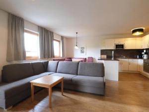 un soggiorno con divano grigio e una cucina di Apartment Edith - IST100 by Interhome a Imst
