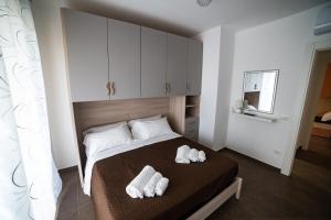 a bedroom with a bed with white towels on it at Appartamenti Tropea Middle Town in Tropea